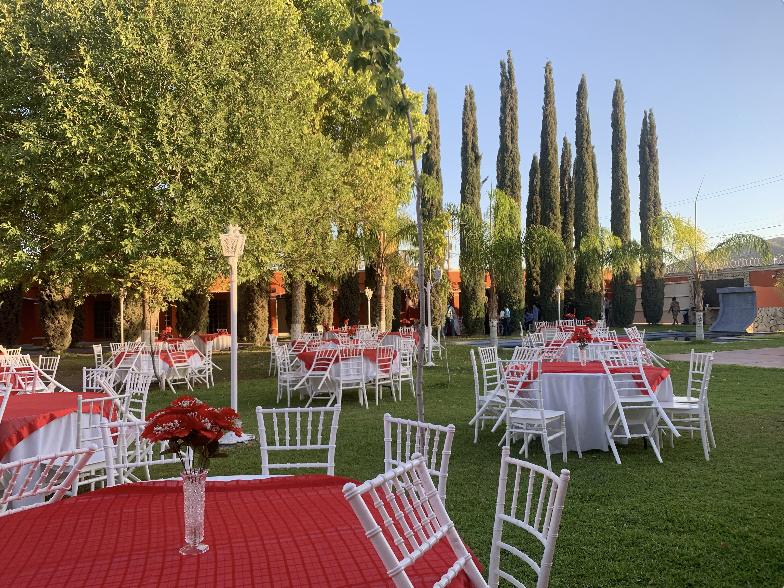 Mesas montadas con mantel rojo en el jardín